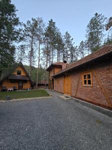 a couple of buildings with trees in the background at Forest soul "Jaslice" - Ozren in Doboj