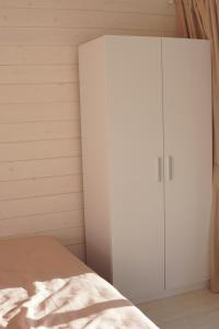 a bedroom with a white cabinet next to a bed at Runa House in Verkhovyna