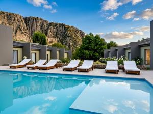 a pool at the resort with lounge chairs and a mountain at Posada del Blanco in Potrerillos