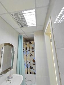 a bathroom with a sink and a shower and a mirror at Tik-Tak Mini-Hotel in Cherkasy