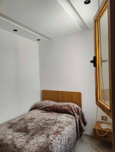 a bedroom with a bed in a white room at 1-bedroom apartment in Monastir