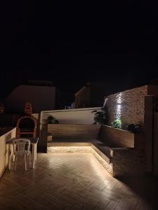 a patio with two chairs and a table at night at 1-bedroom apartment in Monastir
