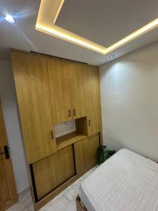a bedroom with a bed and wooden cabinets at 1-bedroom apartment in Monastir