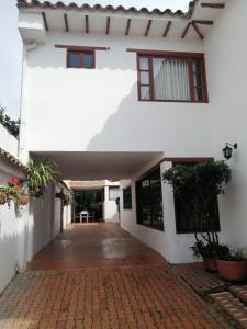 a hallway of a white house with a brick walkway at Casa Leo in Villa de Leyva
