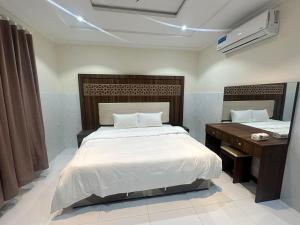 a bedroom with a large bed and a desk at كيان التيسير - حي التيسير in Jeddah