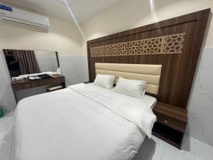 a bedroom with a large white bed and a mirror at كيان التيسير - حي التيسير in Jeddah +19 photos