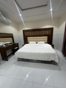 a bedroom with a large bed and a desk at كيان التيسير - حي التيسير in Jeddah