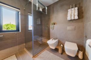 a bathroom with a toilet and a glass shower at Vila das Acácias - Boutique Villa in Wine Country in Alenquer