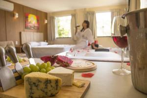 a woman in a room with a table with cheese and wine at Vale Das Araras Nas Videiras in Araras Petropolis