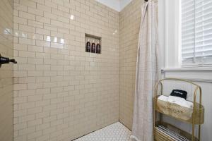 a bathroom with a shower with white tiled walls at Historic Riverview Inn Eight in Chattanooga