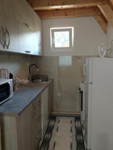 a kitchen with a white refrigerator and a window at House Vasilije in Žabljak