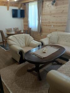 a living room with a table and two couches at House Vasilije in Žabljak