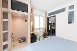 a bedroom with a bed and a desk and a television at Bella Pescara B&B in Pescara