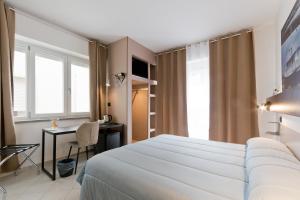 a hotel room with a white bed and a desk at Bella Pescara B&B in Pescara +85 photos