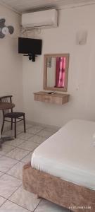 a bedroom with a bed and a tv on the wall at Homer Studio in Nydri