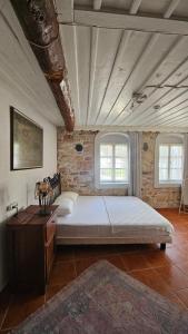 a bedroom with a large bed and a brick wall at Mimosa House Ayvalık in Ayvalık