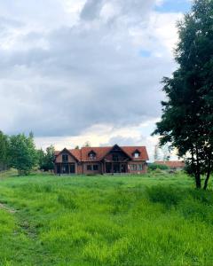 a house in the middle of a grass field at Warmińska Sielanka in Blanki
