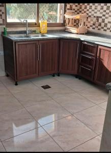 a kitchen with wooden cabinets and a sink at Albaraka-farm in Az Zarqa