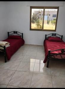two beds sitting in a room with a window at Albaraka-farm in Az Zarqa