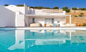 a villa with a swimming pool in front of a house at Santorini Heights in Pyrgos +92 photos