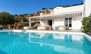 a swimming pool in front of a villa at Santorini Heights in Pyrgos