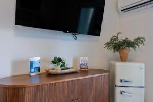 a tv hanging on a wall above a refrigerator at Historic Riverview Inn Suite Ten in Chattanooga