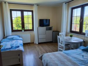 a bedroom with two beds and a table and a tv at Willa Hydrograf - rowery i parking bezpłatnie in Ustka