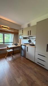 a kitchen with white cabinets and a table in it at Rifugio Artuik 1400 in Marilleva