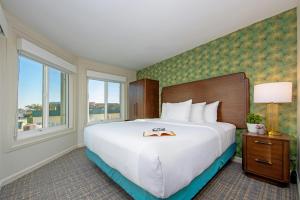 a hotel room with a large bed and a window at Peacock Suites in Anaheim