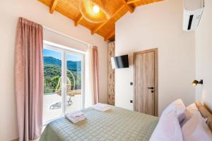 a bedroom with a bed and a large window at Villa Mario by Villa Plus in Katokhórion