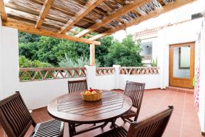 a patio with a wooden table and chairs at Alpujarra Relax with Terrace in Órgiva