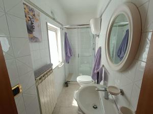 a bathroom with a sink and a toilet and a mirror at La terrazza sul fiume in Spoleto
