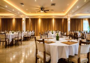 a banquet hall with white tables and chairs at Araliya Hotel in Badulla