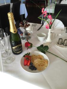 a table with a plate of food and a bottle of champagne at Red Gate House B&B in Malin