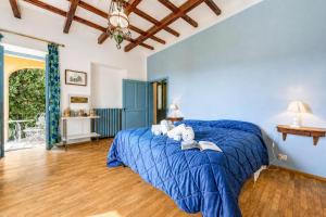 a bedroom with a blue bed and a wooden floor at Villa I Tre Archi for 6 with Private Garden - Happy Rentals in Pisano