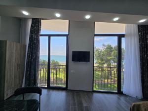 a living room with sliding glass doors and a television at Welcome3 in Achʼqva