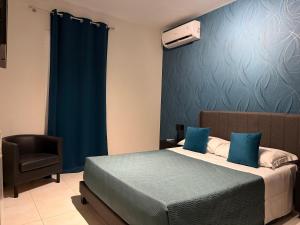a bedroom with a bed with a blue wall at Katrina's Home alloggio turistico in Fiumicino