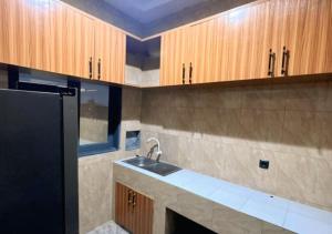eine Küche mit Spüle und Holzschränken in der Unterkunft Hôtel 550 in Cotonou Cadjehoun