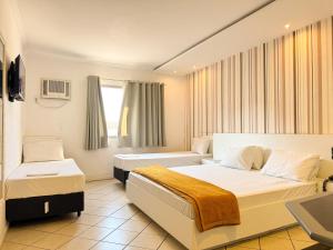 a hotel room with two beds and a window at Império Hotel in Santos +46 photos
