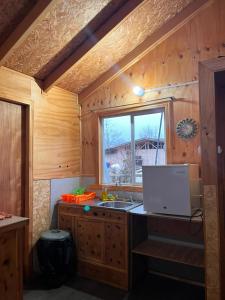 a kitchen with a sink and a window at Cabaña Donde la Bety in Villa Santa Lucía +3 photos