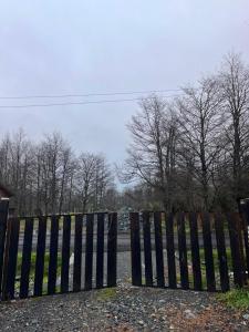 a black gate in front of a fence at Cabaña Donde la Bety in Villa Santa Lucía