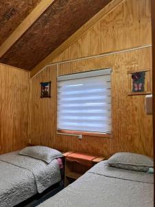 a bedroom with two twin beds and a window at Cabaña Donde la Bety in Villa Santa Lucía