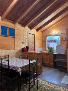 a dining room with a table and a kitchen at Cabaña Donde la Bety in Villa Santa Lucía