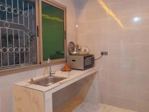 a kitchen with a sink and a microwave at Relax House 2 in Al Massira Airport