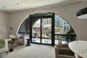 a living room with an arched window and a balcony at The Satire, Autograph Collection in Alexandria
