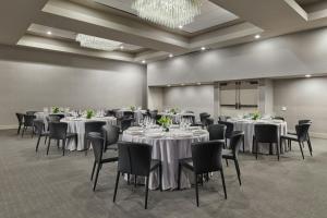 a conference room with tables and chairs and a chandelier at The Satire, Autograph Collection in Alexandria