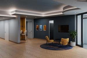 a room with chairs and a table and a tv at Four Points Flex by Sheraton Parma in Parma
