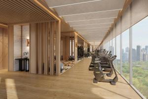 a gym with a row of exercise machines at Jakarta Marriott Hotel Gelora in Jakarta
