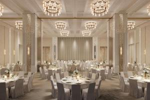 a banquet hall with white tables and chairs and chandeliers at Jakarta Marriott Hotel Gelora in Jakarta +15 photos