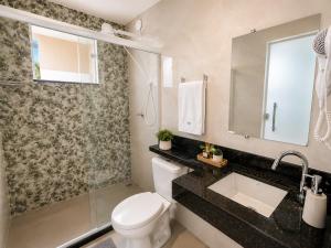 a bathroom with a toilet and a sink and a mirror at Pousada Recanto do Chef in Búzios +34 photos